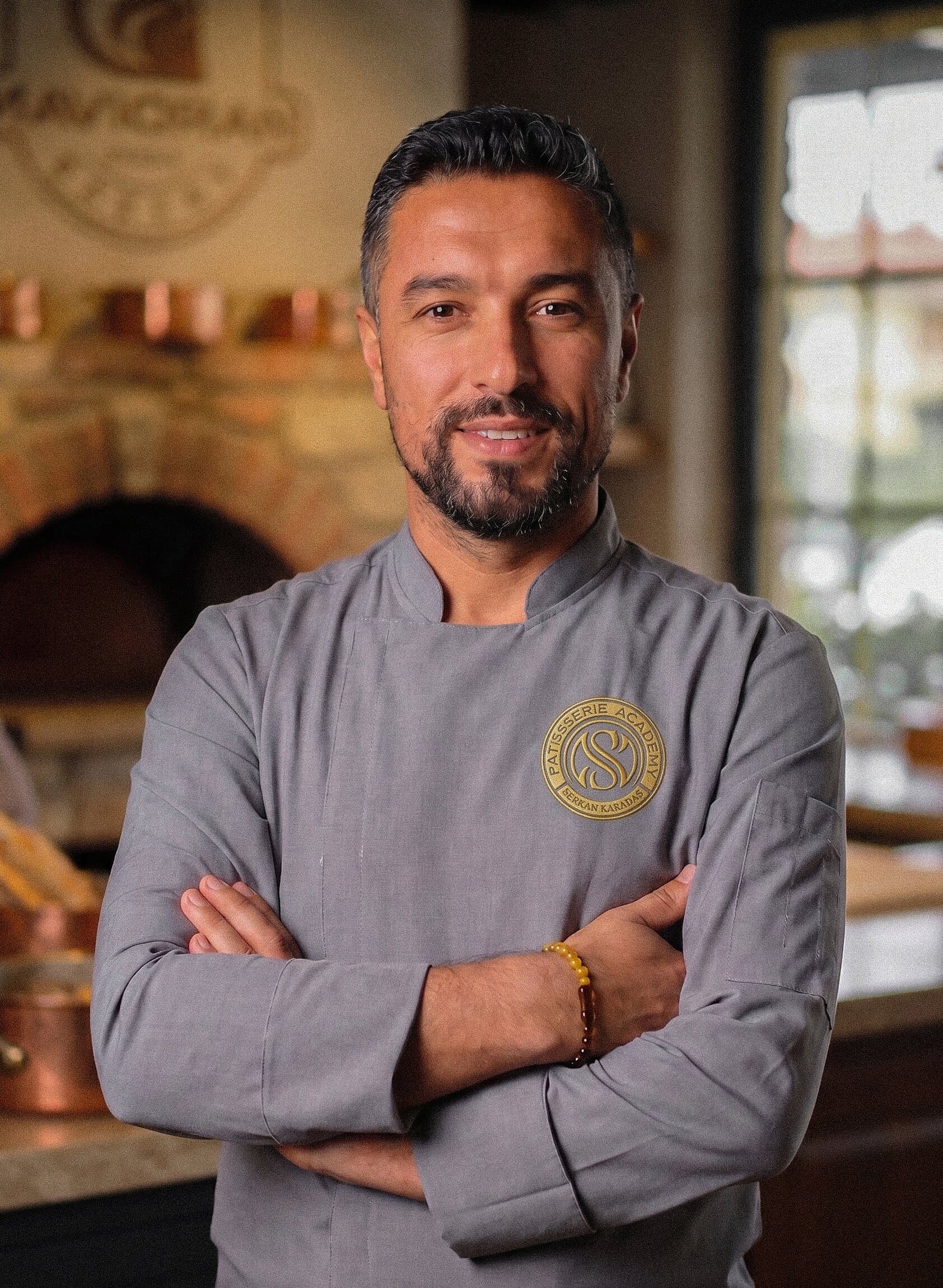 Patisserie Academy kurucusu Chef Serkan Karadaş’ın fırın ortamında, gri şef ceketiyle profesyonel portresi